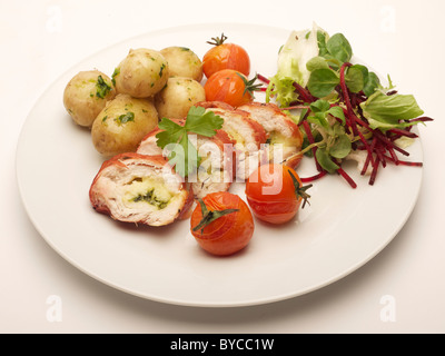 Warme Mahlzeit auf dem Teller, einschließlich Huhn, Kartoffeln, Tomaten und Salat Stockfoto