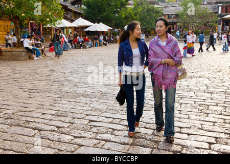 Zwei schöne moderne chinesische junge Frauen gehen in die Altmarkt, Lijiang, Provinz Yunnan, China. JMH4749 Stockfoto