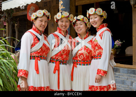 Vier junge Naxi Frauen in traditioneller Tracht in der Altstadt von Lijiang, Provinz Yunnan, China. JMH4761 Stockfoto