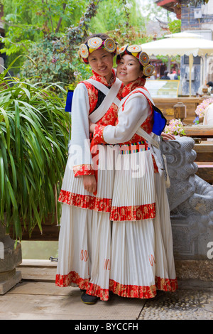 Zwei junge Naxi Frauen in traditioneller Tracht in der Altstadt von Lijiang, Provinz Yunnan, China. JMH4767 Stockfoto