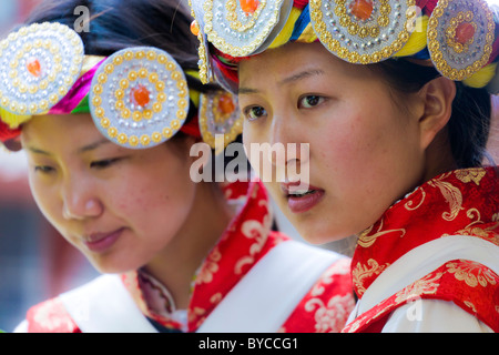 Zwei junge Naxi Frauen in traditioneller Tracht in der Altstadt von Lijiang, Provinz Yunnan, China. JMH4769 Stockfoto