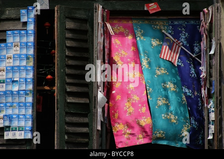 Eine kleine malaysische Flagge ist auf dem Display neben einem shuttered Fenster in einem heruntergekommenen Gebäude in Georgetown, Penang, Malaysia. Stockfoto