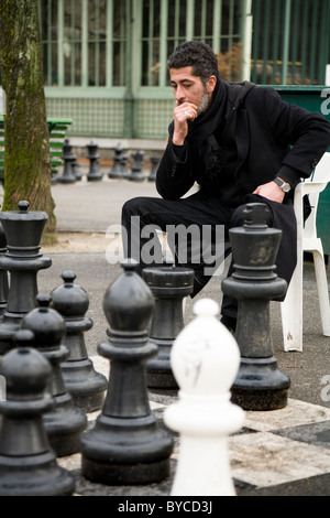 Player wiegt Taktik Spielen übergroße / große / riesige / big Schach in einem öffentlichen Park in Genf / Genève, Schweiz. Stockfoto