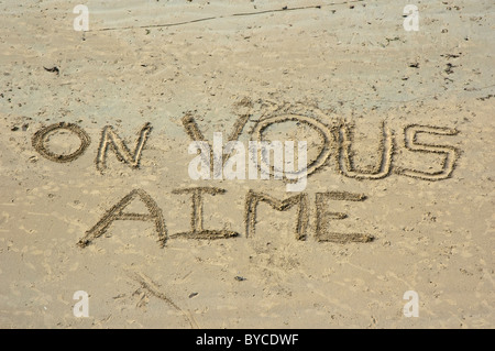 Auf Vous steht Aime (wir lieben dich) an einem Sandstrand. Stockfoto