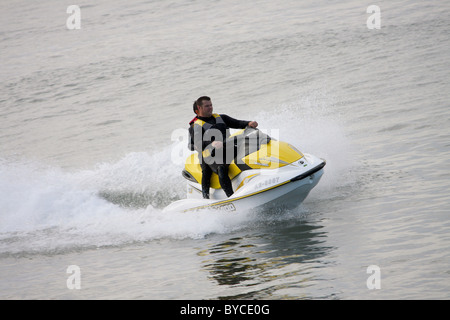 Zwei Personen auf einem Jet Ski; Jet-Ski an einem kalten Tag durch in Neoprenanzüge Stockfoto