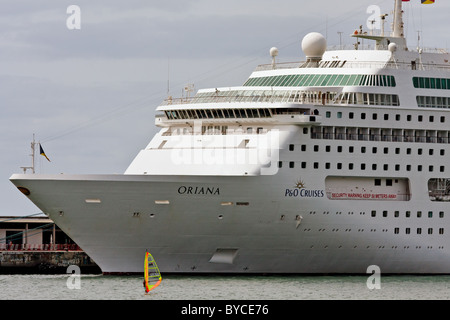 Windsurfer im Hafen von Funchal erscheint unbedeutend gegen Kreuzfahrtschiff Stockfoto