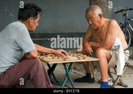 Zwei Männer spielen chinesisches Schach auf einem Bürgersteig, Hutong District, Beijing, China. Stockfoto