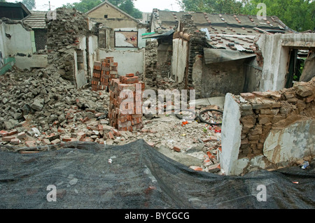 Stapel von Steinen neben zerstörten Häusern, Hutong District, Beijing, China. Stockfoto