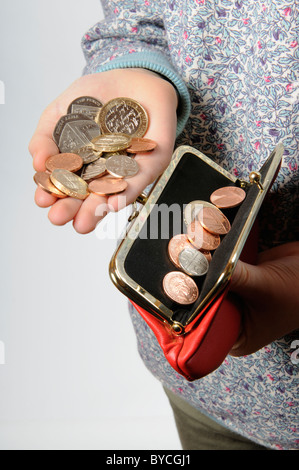 Kind an der Hand mit einem roten Handtasche und britisches Geld Stockfoto