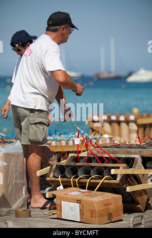 Männer, die Installation von Feuerwerk Bomben auf einem schwimmenden Floß Verlegung auf dem Sand für den Job. 14. Juli St Tropez, Frankreich Stockfoto