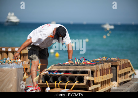 Mann Feuerwerk Bomben auf einem schwimmenden Floß zu installieren und halten Sicherungen in den Mund. 14. Juli St Tropez, Frankreich Stockfoto