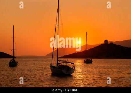 Griechenland, Insel Symi. Sonnenuntergang am Panormitis-Bucht, wo sich das sehr bedeutenden Kloster Panormitis befindet. Stockfoto