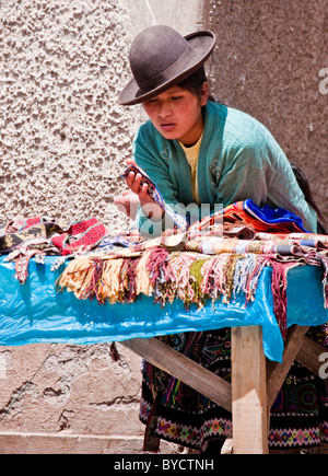 Dame arbeitet auf dem Markt von Pisac, Heiliges Tal, Peru, Südamerika. Stockfoto