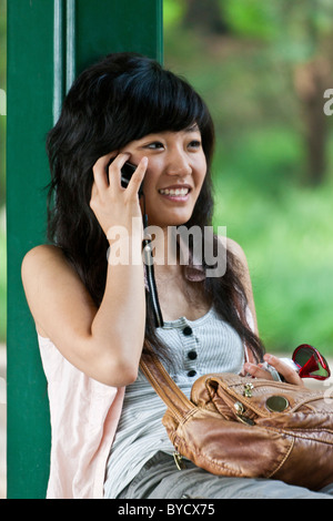 Attraktive junge Chinesin spricht über Handy auf dem Gelände des neuen Sommerpalast, Peking, China. JMH4807 Stockfoto