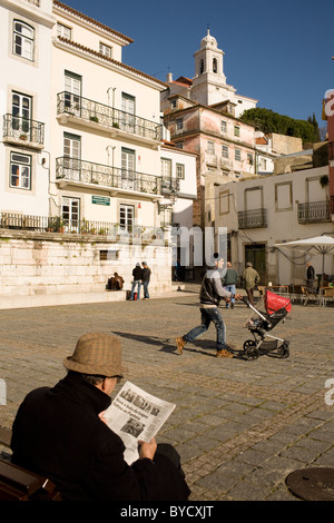 Mann liest Zeitung an einem Platz im Stadtteil Alfama, Lissabon, Portugal Stockfoto