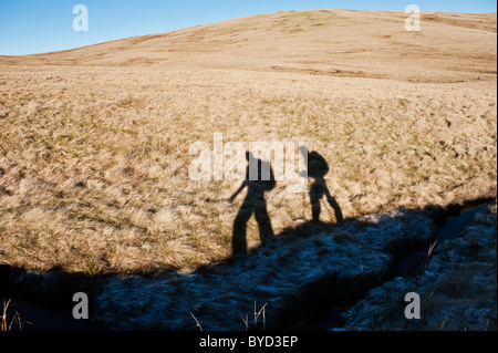 Schatten der zwei Wanderer auf Grünland, Brecon Beacons National Park, Wales Stockfoto