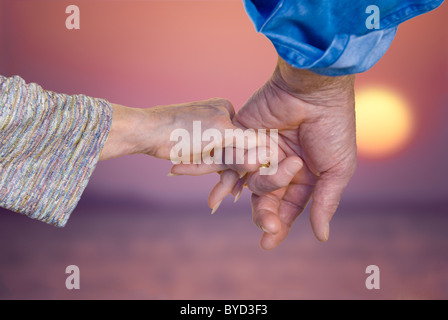 Älteres Paar Hand in Hand bei Sonnenuntergang in Nahaufnahme Stockfoto