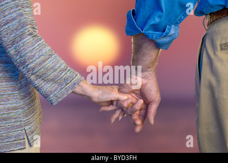 Älteres Paar Hand in Hand bei Sonnenuntergang in Nahaufnahme Stockfoto