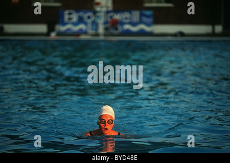 Am frühen Morgen regelmäßige Schwimmer schwimmt einsame Längen im Brockwell (Brixton) Lido vor Massen ankommen Stockfoto