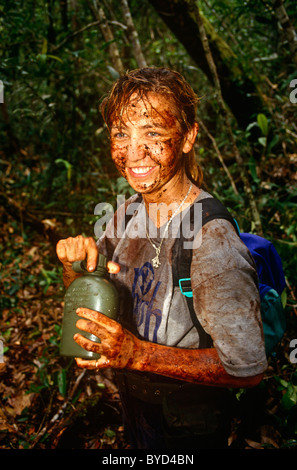 Junges Mädchen Freiwilligen ist nach einer Tätigkeit auf einem Raleigh International-Expedition in den Regenwäldern von Brunei im Schlamm verkrustet. Stockfoto