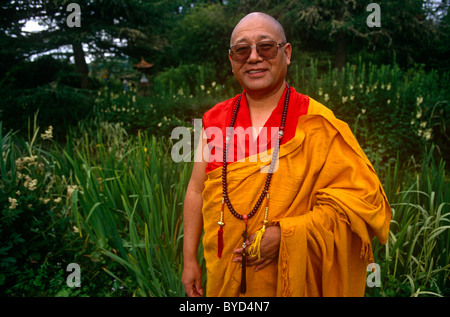 Porträt des tibetisch-buddhistischen Lama Yeshe Losal Rinpoche stehend in den Gärten von Samye Ling buddhistisches Zentrum. Stockfoto