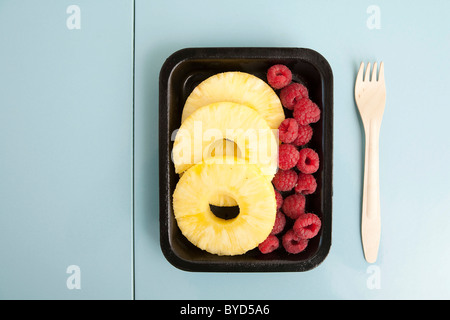 Verpackte Ananasscheiben und Himbeeren Stockfoto