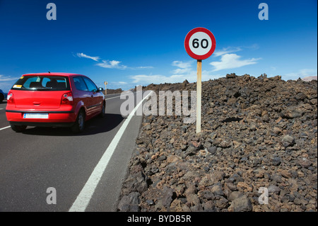 Rotes Auto auf einer Straße, die Vulkanlandschaft am Los Hervideros, Nationalpark Timanfaya, Lanzarote, Kanarische Inseln, Spanien, Europa Stockfoto