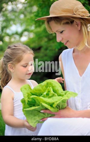 Junge Mutter und Tochter mit Salat Stockfoto