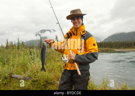 Junge Frau Angeln, präsentieren ihr Fang, große arktische Äsche (Thymallus Arcticus), Wind River, Yukon Territorium, Kanada Stockfoto