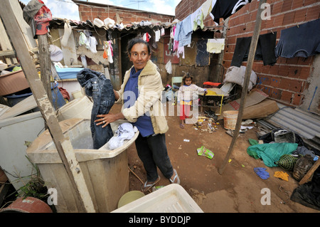 Schwangere Frau, 43, Wäschewaschen vor einer schäbigen Hütte in einer Favela oder Shanty Town, das Familienleben durch das sammeln, Stockfoto