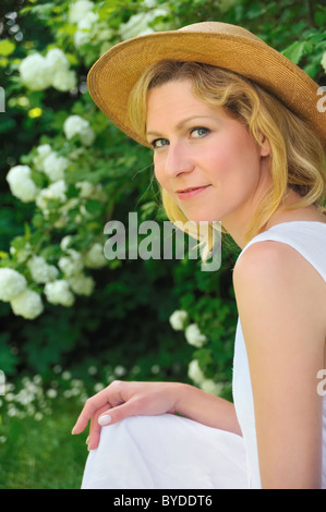 Elegante junge Frau ruht im Garten Stockfoto