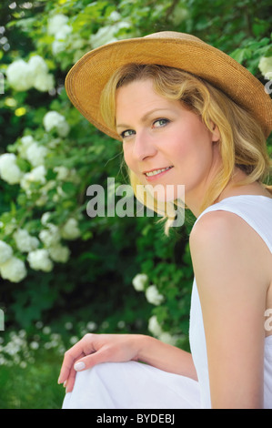 Elegante junge Frau ruht im Garten Stockfoto