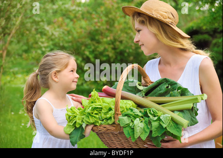 Junge Mutter und Tochter mit frischem Gemüse Stockfoto
