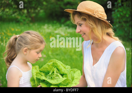 Junge Mutter und Tochter mit frischem Salat Stockfoto