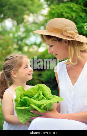 Junge Mutter und Tochter mit Salat Stockfoto