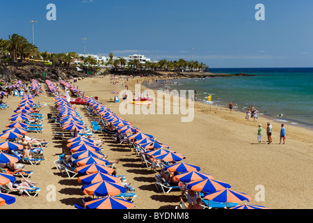 Sonnenschirme am Sandstrand, Playa Grande, Puerto del Carmen, Lanzarote, Kanarische Inseln, Spanien, Europa Stockfoto