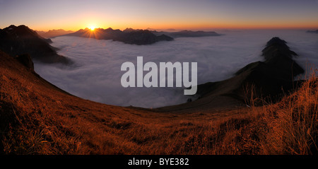 Bergtal unter Nebel mit Berggipfeln im Abendlicht, Allgäuer Alpen, Kleinwalsertal Tal, Vorarlberg, Österreich Stockfoto