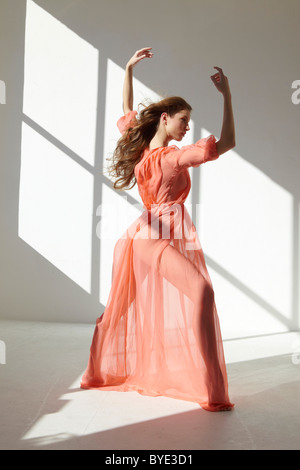 Ballett-Tänzerin trägt ein rotes Kleid in einer Tanz-pose Stockfoto