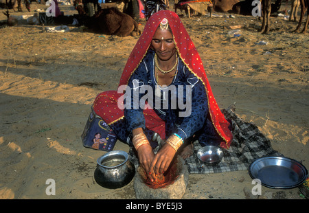 Indische Frau in traditioneller Kleidung zerkleinern Chilischoten in einen Mörser, Pushkar, Rajasthan, Indien, Asien Stockfoto