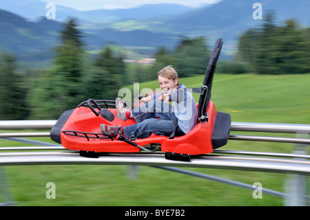 Junge amüsiert sich auf eine Sommerrodelbahn laufen, SoellereckRodel, Oberstdorf, Allgäu, Bayern, Deutschland, Europa Stockfoto