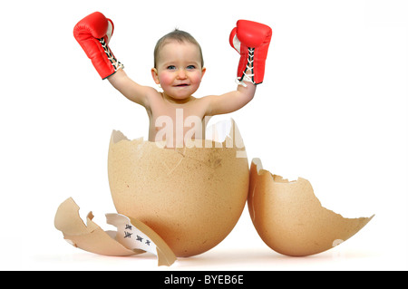 Schöne Baby mit Boxhandschuhen brechen das Ei Stockfoto