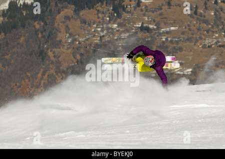 Ein Skifahrer führt eine Hand ziehen über einen Grat in den Skiort Courchevel in Frankreich. Stockfoto