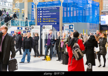 Londoner Pendler Bahnhof Liverpool Street Passagiere Masse bis zu Ankunft Abreise board Warten auf der Bahn einige auf Zelle oder Handys suchen Stockfoto