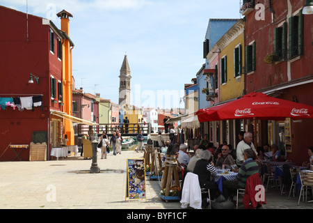 Restaurant-Szene in Burano Italien mit Campanile von San Martino im Hintergrund Stockfoto