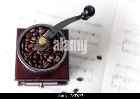 Kaffeemühle mit Kaffeebohnen zu den Noten Stockfoto