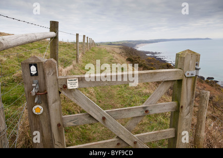 Blick entlang der South West Coastal Path in Richtung Rame Head mit einem Holztor im Vordergrund, Cornwall, England. Stockfoto