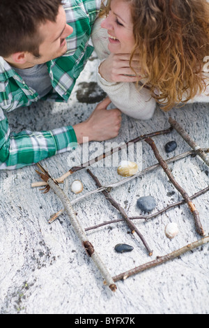 Mitte erwachsenes paar Tic Tac Toe spielen, am Strand Stockfoto