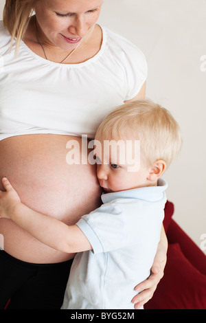 Junge schwangere Bauch hören Stockfoto