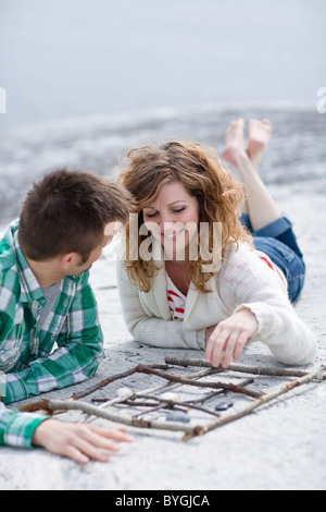 Mitte erwachsenes paar Tic Tac Toe spielen, am Strand Stockfoto