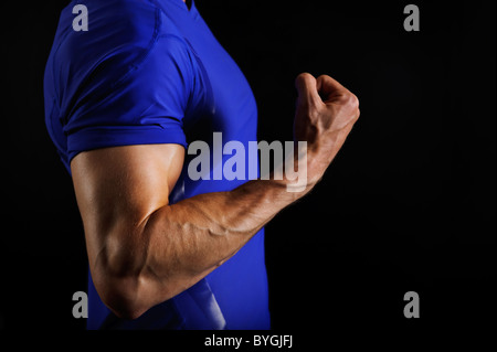 Männlicher Athlet biegen Armmuskeln Stockfoto